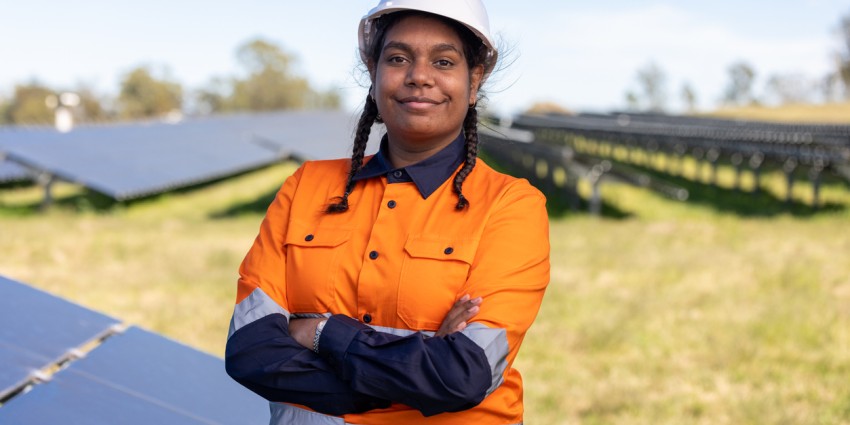 Image of young resilient looking Aboriginal woman in mining work clothes with arms folded
