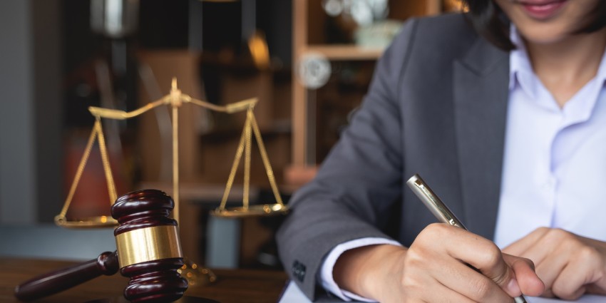 Woman lawyer writing official documents with a gavel