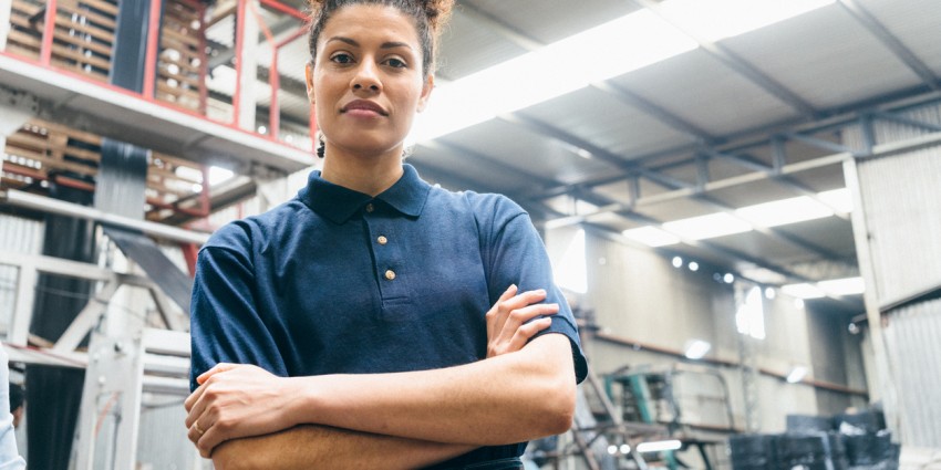 Image of young confident looking woman in the workplace with here arms folded