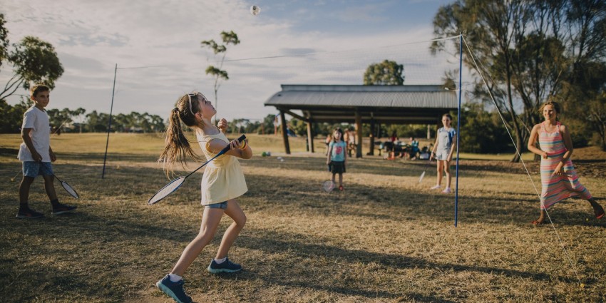 photo of a group of young people playing badminton outdoors