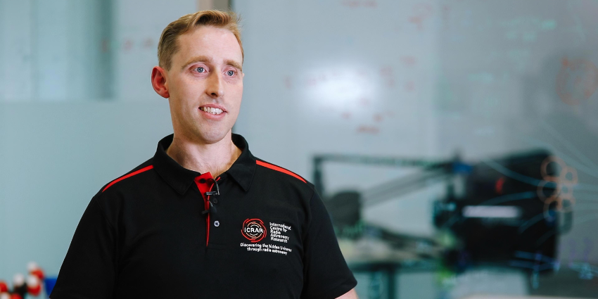 A portrait of man wearing a black and red polo shirt 