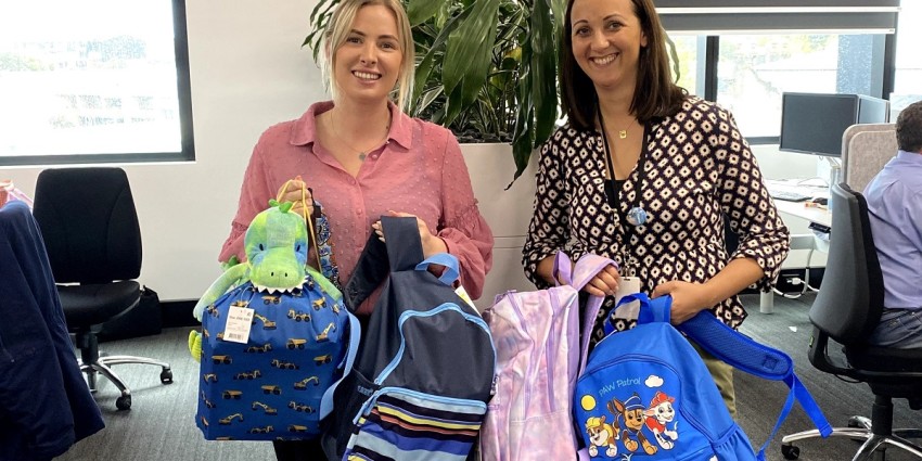 Photo of Communities staff members Charlotte Newton and Rosanna Blake with their Care Bags for children in care.