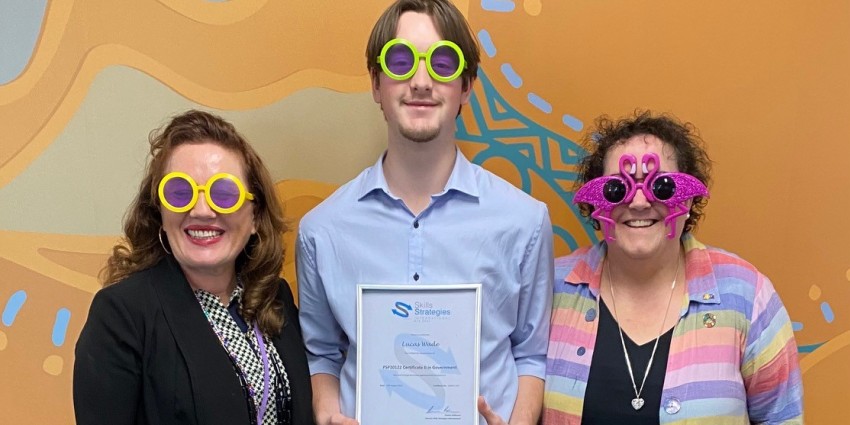 Photo of student Lucas Wade flanked by Communities staff and wearing funny sunglasses