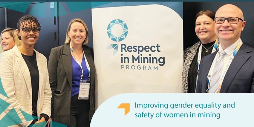 Photo of a group of people (including Communities Director General Mike Rowe) and the Respect in Mining Program banner