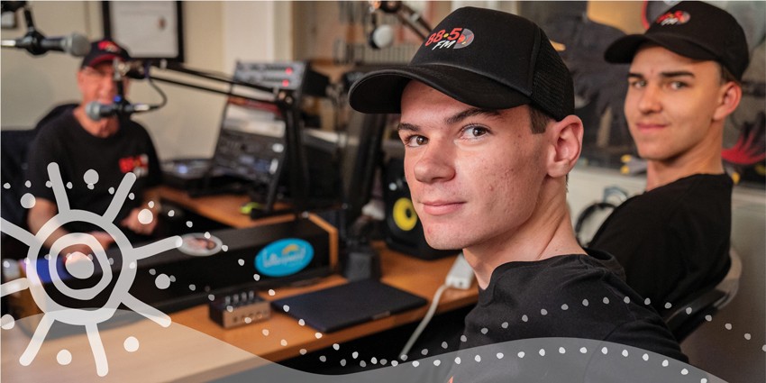photo of two teenagers in a radio station with the radio announcer all wearing the radio station caps