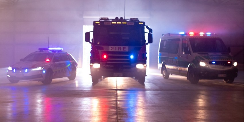 a police car, fire truck, and ambulance truck parked next to each other with their lights on