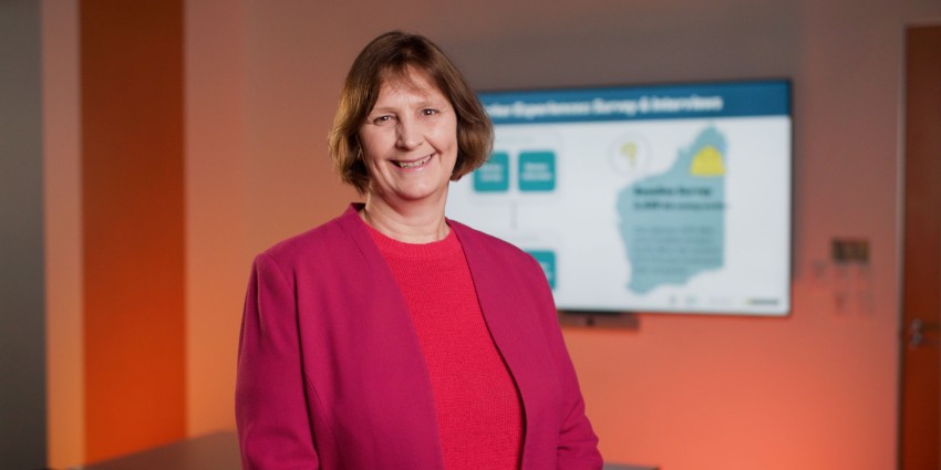 Headshot of a happy Sharon parker in a bright magenta balzor