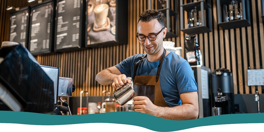A barista pouring coffee in a cafe