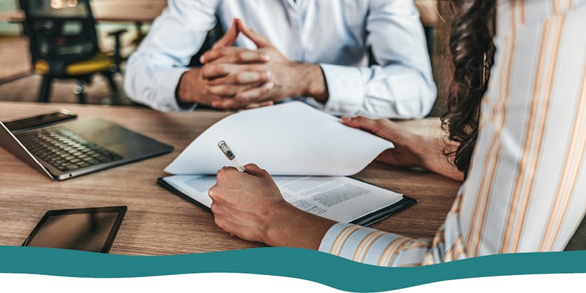 A person signing pages of documents