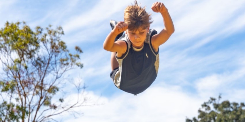 Photo of a boy playing in a playground, mid air