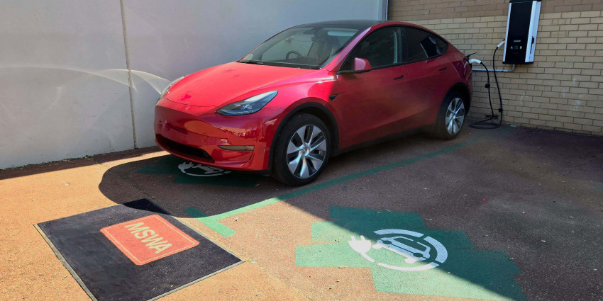 Red car in parking space next to an EV charger at MSWA
