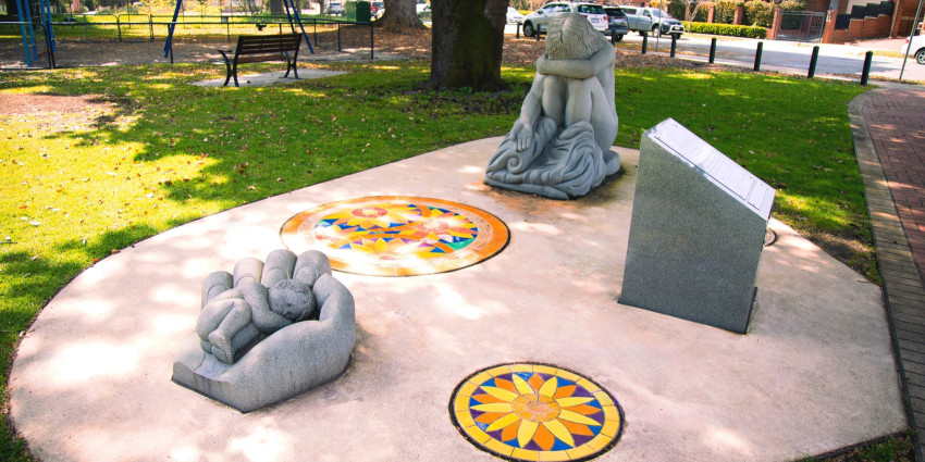Photo of a memorial sculpture called Empty Arms – Broken Lives, representing mothers separated from their children by adoption. It includes a sculpture of a baby and a crying mother