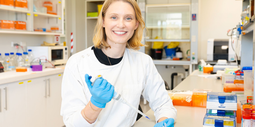 psa finalist jessica kretzmann with sample tube on one hand and pipet on the other