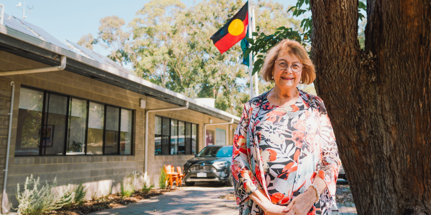 psa finalist rhonda marriot standing in front of office with Aboriginal flag in the background