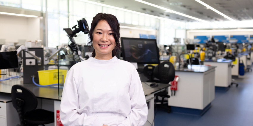 Rina in her lab wearing her lab coat