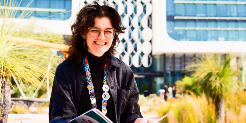 psa finalist shakara liddelow sitting in a park with a report book on their hand