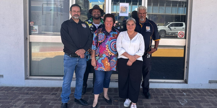 a group of staff, including Aboriginal men and women, in an outdoor setting