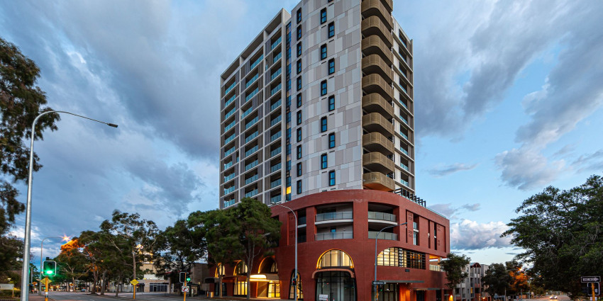 A tall housing complex and the urban city street below the building
