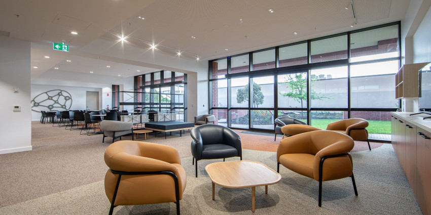 An internal communal area featuring tables, chairs and sofas.