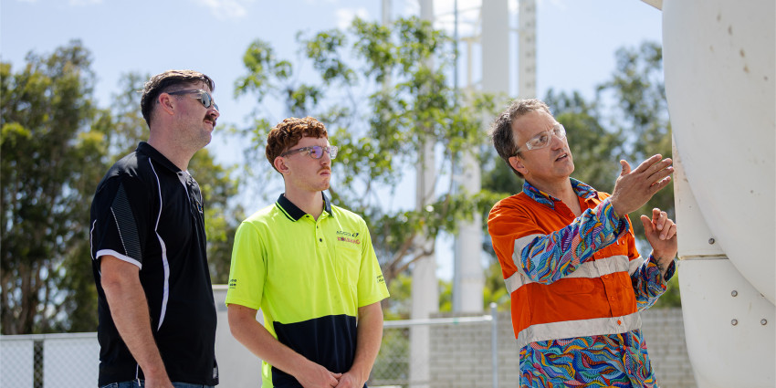 two students watching the lecturer showing them the new clean energy equipment