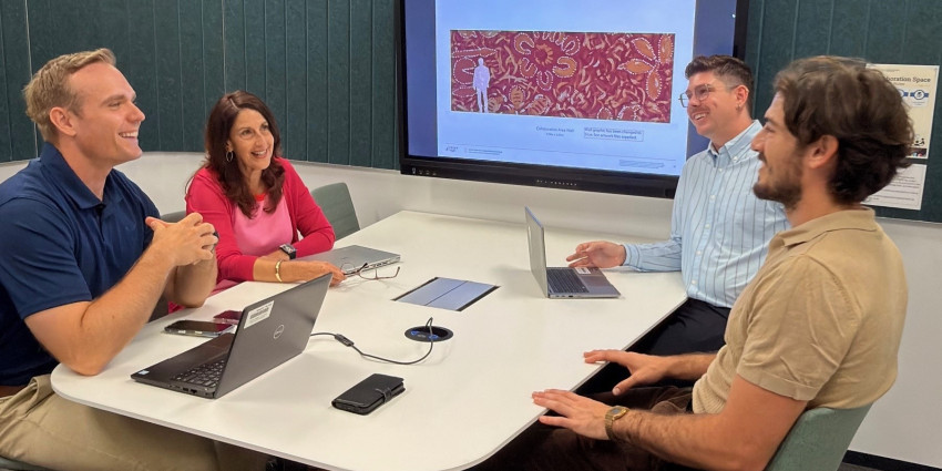 Four Department of Communities staff in a meeting room having a meeting