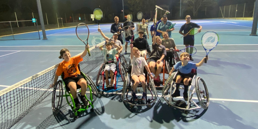 A group of wheel-chair tennis players on a tennis court