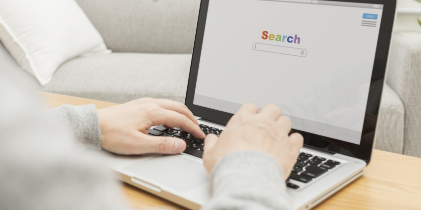a laptop placed on a desk with someone doing a google search