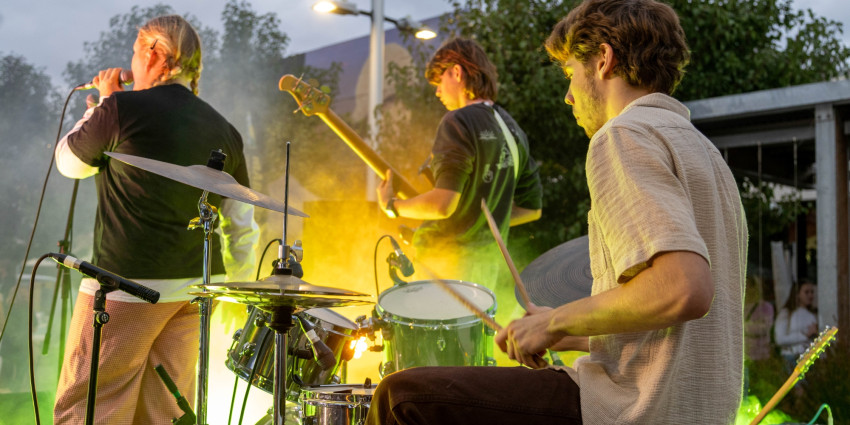 a group of three young musicians on stage playing music