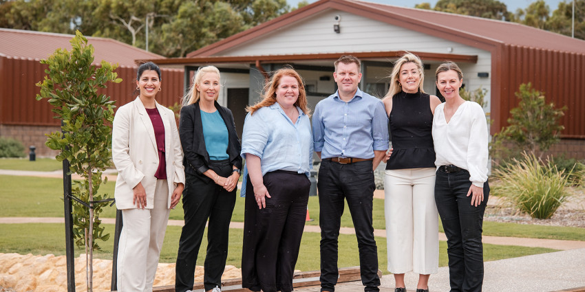 a group of well-dressed adults standing outside the Geraldton Short Stay building