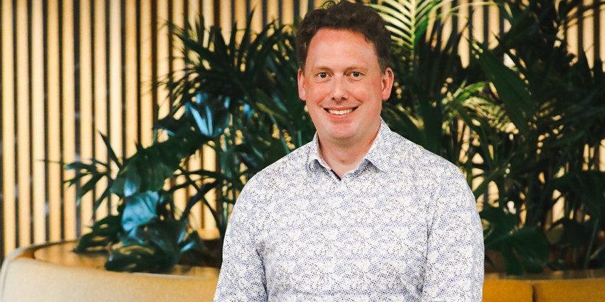 a man smiling, well dressed, in an indoor setting