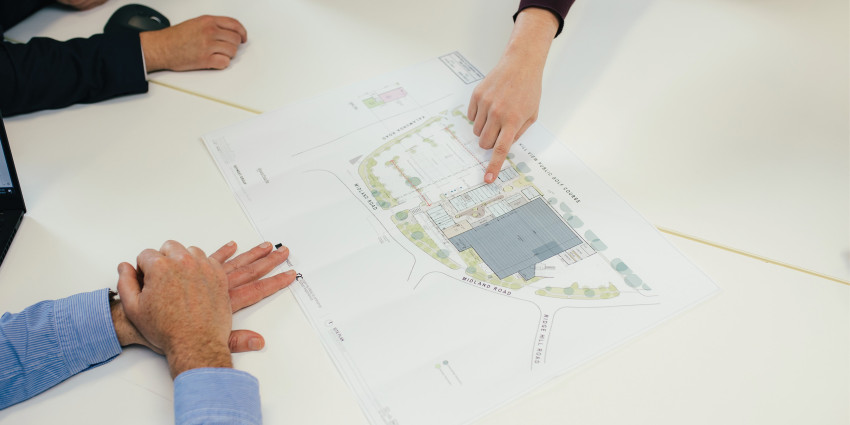 hand pointing at a large-scale map