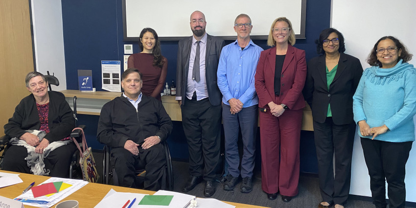A meeting room and a group of 7 people who are the current Lived Experience Advisory Council plus the Minister for Disability Hannah Beazley