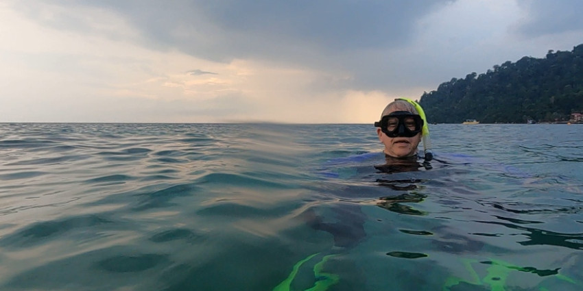 a middle age man snorkeling in the ocean