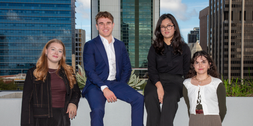 four young professional with the the metropolitan tall buildings in the background