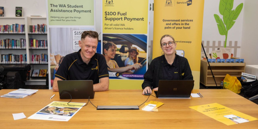 two people sitting at a table and smiling at the camera