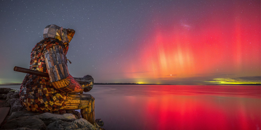 giant sculpture overlooking the aurora in the sky