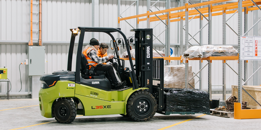 Person operating a forklift during training in a warehouse environment.