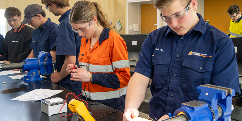 Students completing electrical training activities in a classroom workshop.
