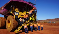 Mine workers in front of a large excavator