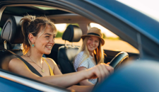 Young driver and passenger in a car smiling