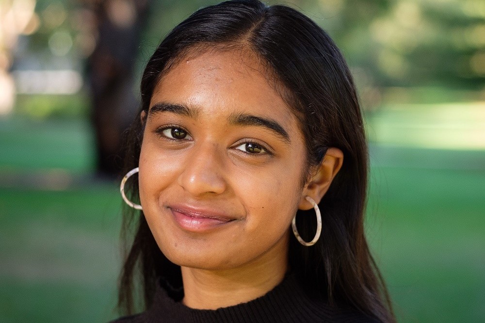 Head and shoulders photo of a young women with trees and grass in the background
