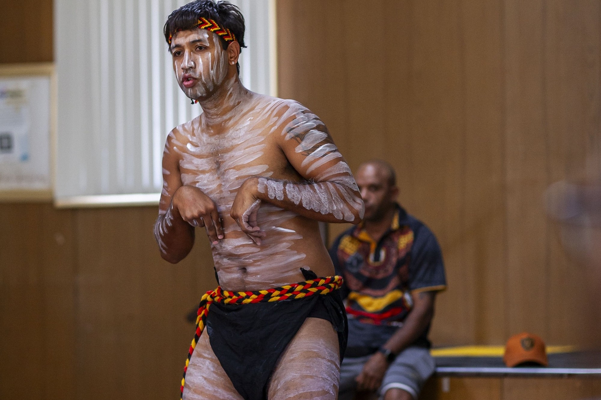 photo of a young Aboriginal adult doing a traditional dance ceremony