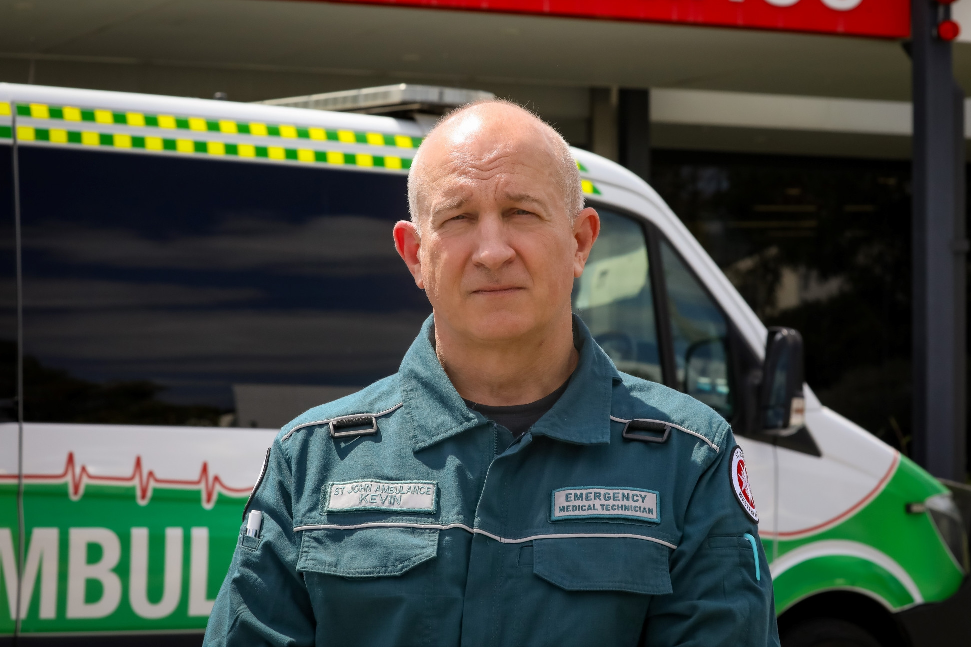 a first response worker Kevin Brown in uniform in front of an ambulance