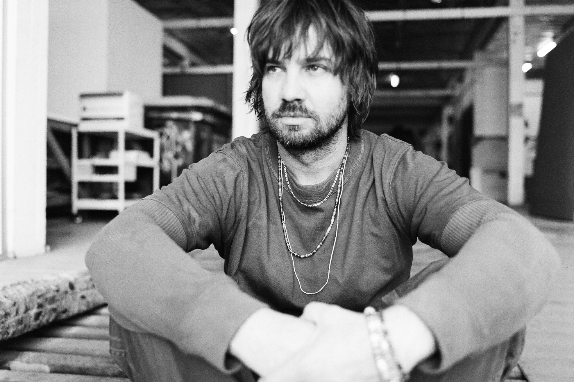 A man casually dressed sitting on the ground