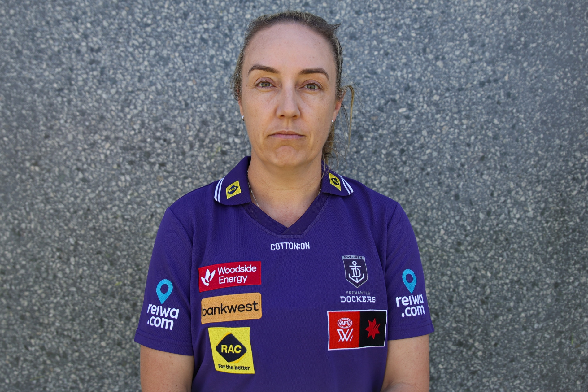 Photo of an AFLW coach wearing a Fremantle Dockers sports top