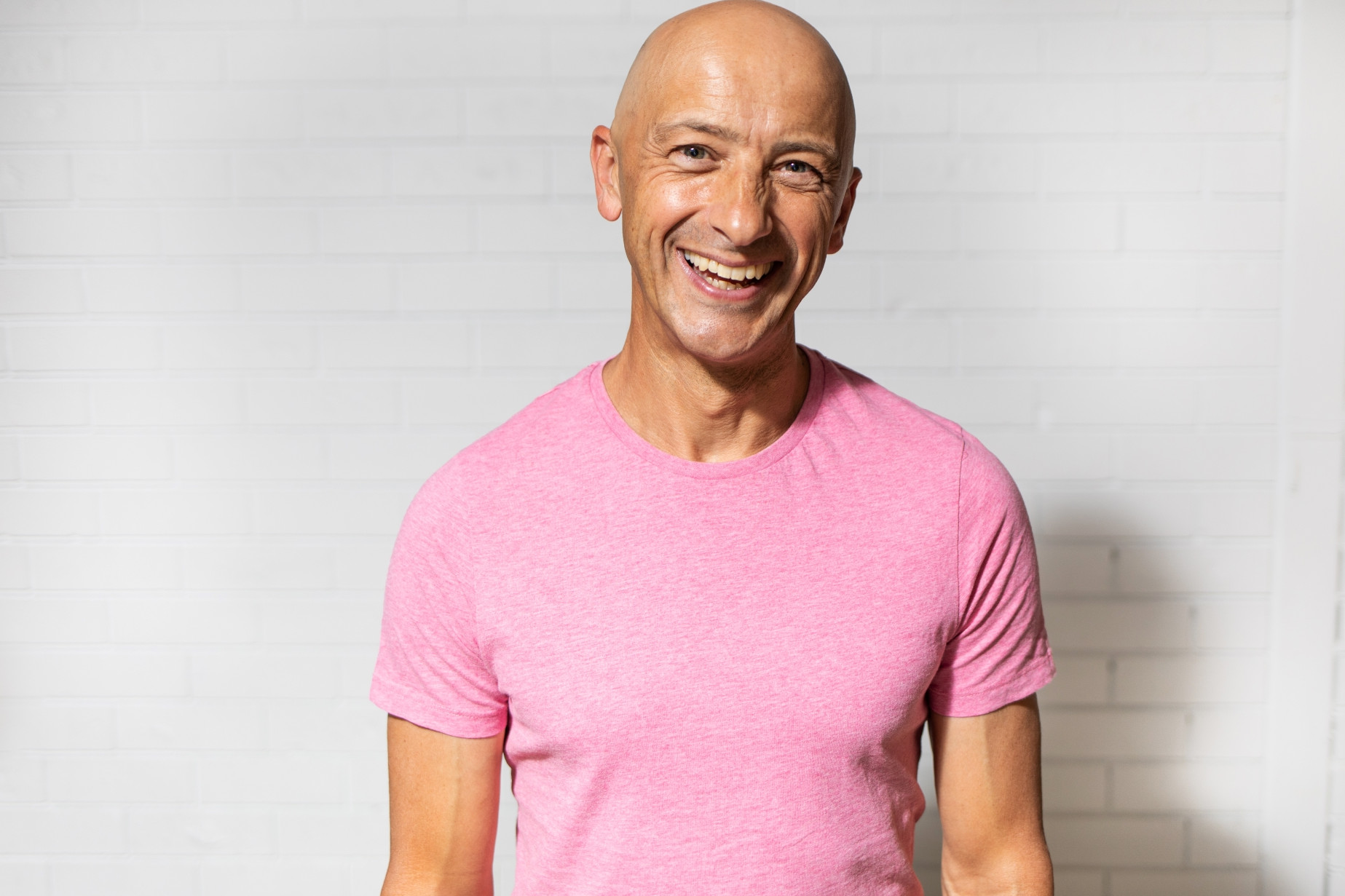 A man wearing a pink short smiling